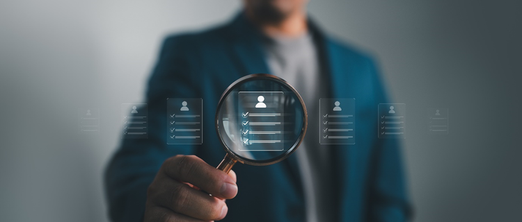 Person holding a magnifying class over a conceptual image of a completed personal form.