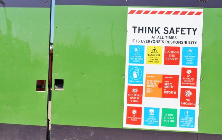 Photo of a safety poster on the gates to the entrance of a workplace with a range of safety messages.