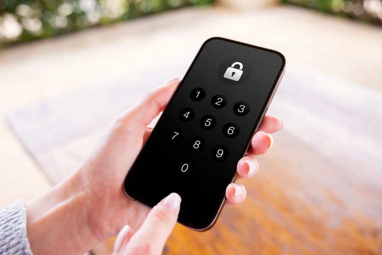 A person entering a PIN code on a smartphone to unlock the screen, highlighting security and device access.
