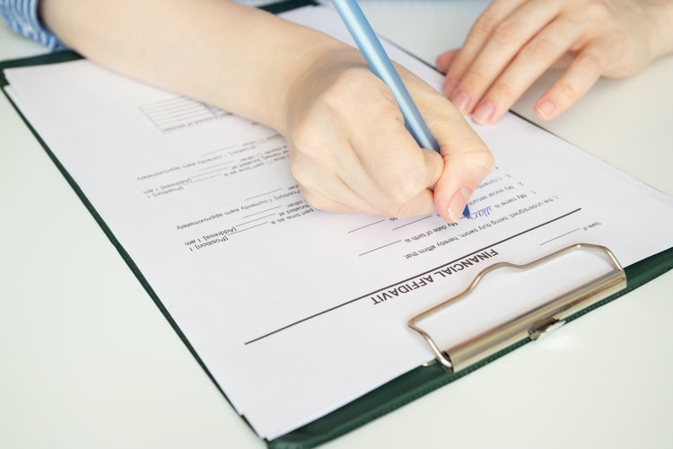 A person fills out a financial affidavit.