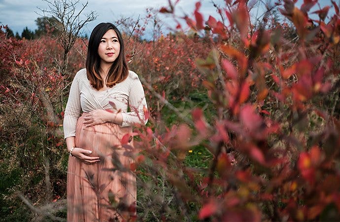 A pregnant parent posing outside for a maternity photo