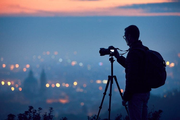 Photographer setting up his camera at twilight