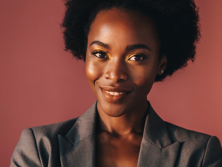 Portrait photoréaliste d’une femme fictive aux cheveux naturels avec un arrière-plan chaleureux de couleur terracotta, généré par l’IA d’Adobe Firefly à des fins commerciales
