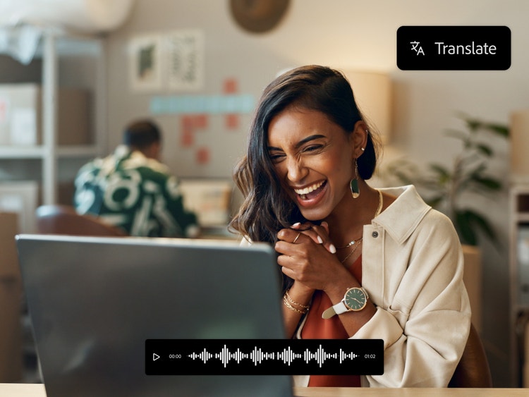 Femme souriante assise devant un ordinateur, qui utilise les outils de traduction par IA pour s’adresser à de nouveaux publics francophones