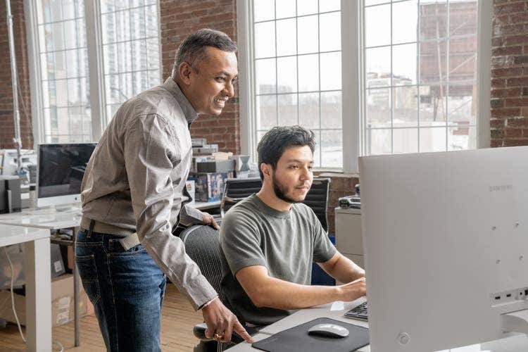 Duas pessoas discutem como diminuir o tamanho do arquivo PDF usando um Mac.