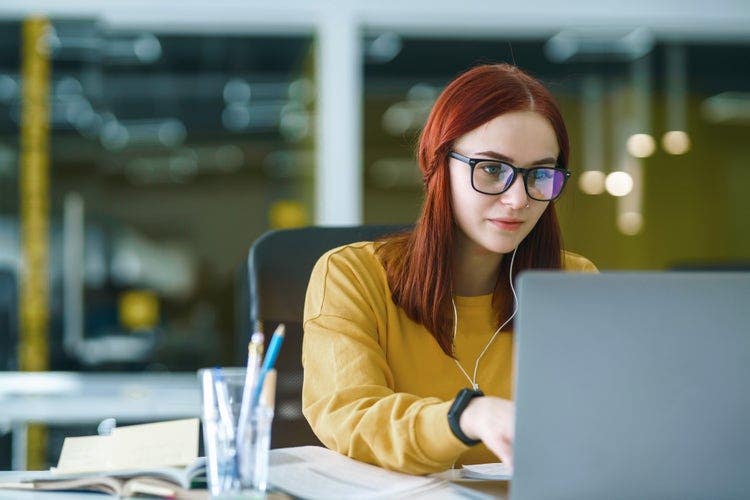 Uma mulher utiliza um notebook para converter os documentos do OpenOffice em PDFs.