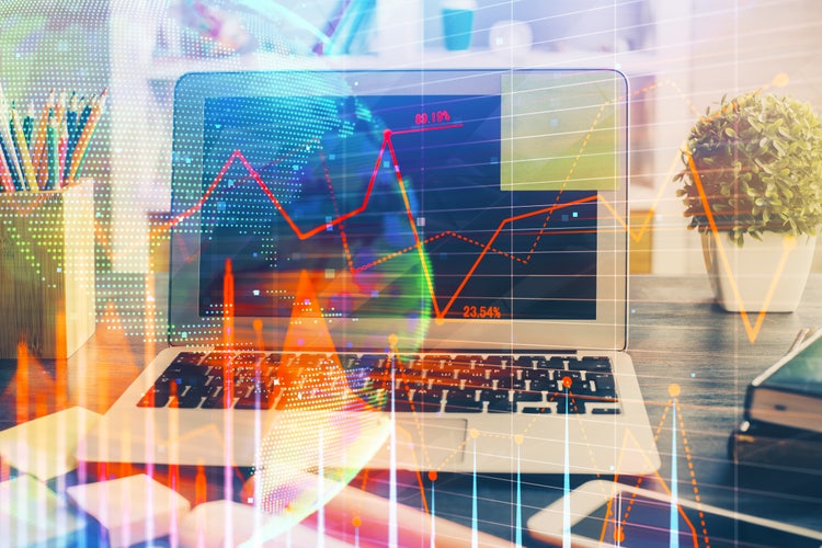 Notebook, mesa, gráficos e dados financeiros