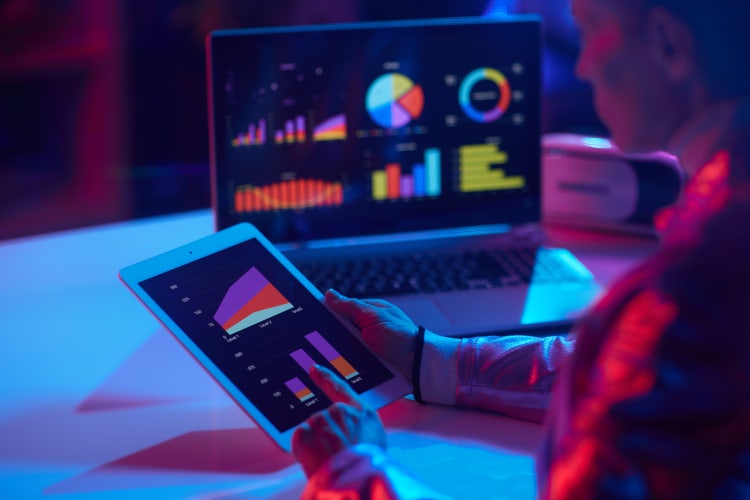 Analista, tablet, notebook e painéis de dados