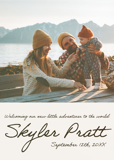 "Welcoming our new little adventurer to the world Skyler Pratt" birth announcement with a family sitting at a table with a lake and mountains in the background