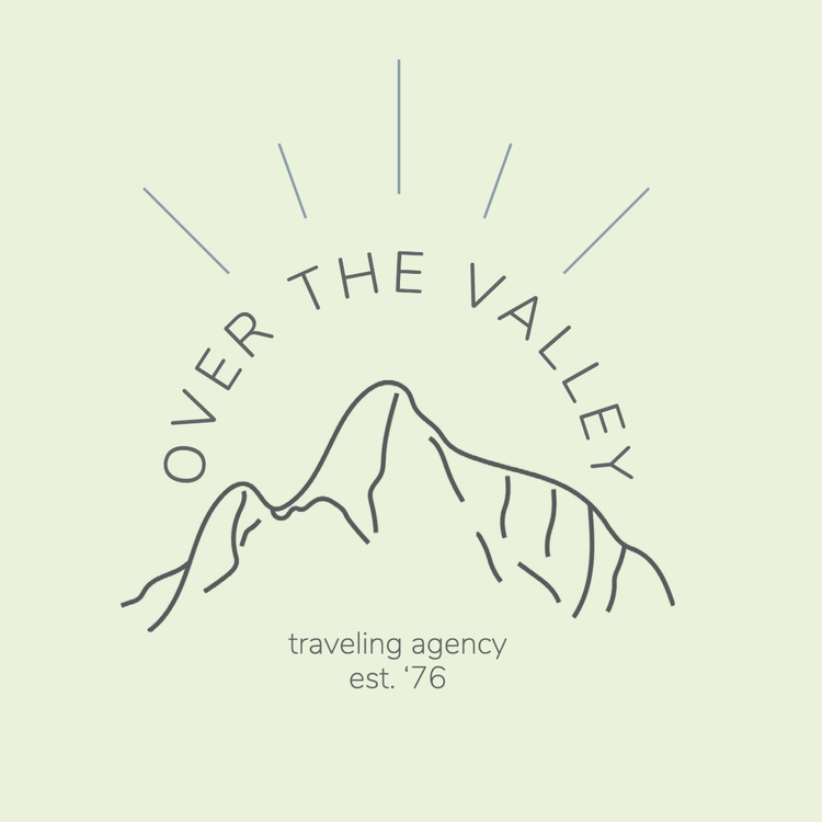 Over the Valley traveling agency est. '76 logo written in the fonts Nunito Light and ExtraLight with an outline of a mountain