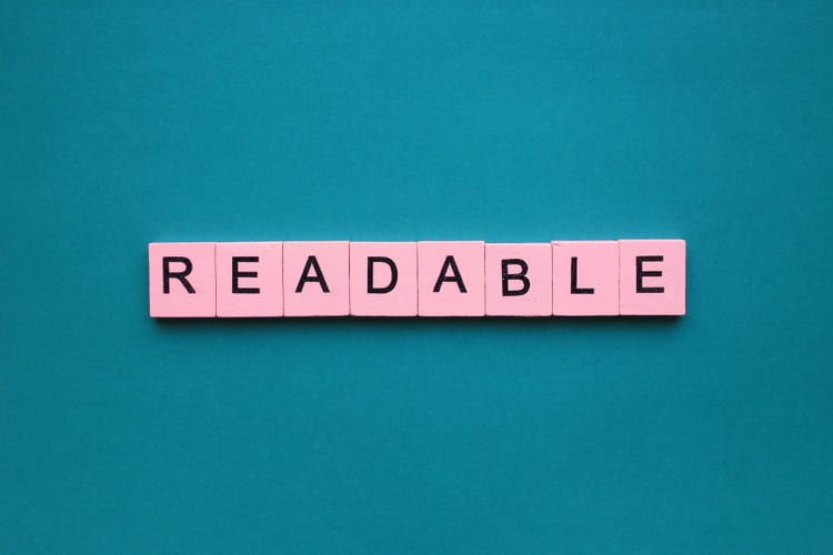 "Readable" spelled out with light pink letter tiles against a solid blue background