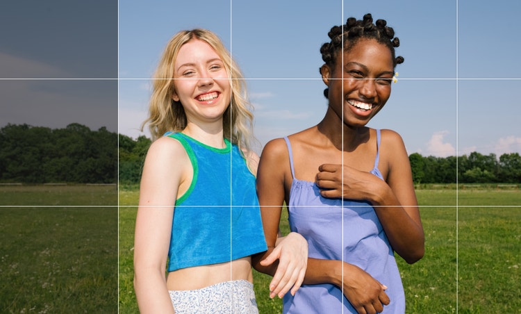 Duas mulheres de braços dados com a imagem expandida para um enquadramento mais amplo.