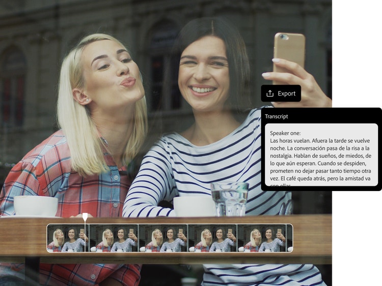 Due donne dietro la vetrina di un bar registrano un video con lo smartphone usando il doppiaggio IA.