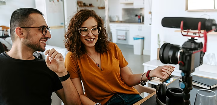Два человека сидят перед камерой и снимают видеоклип