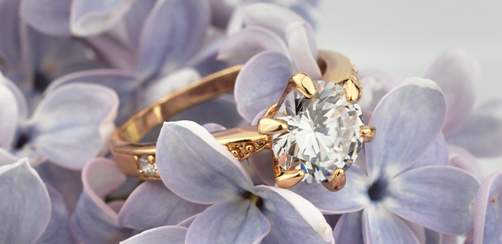 Fotografia macro de anel de diamante sobre leito de flores de lavanda