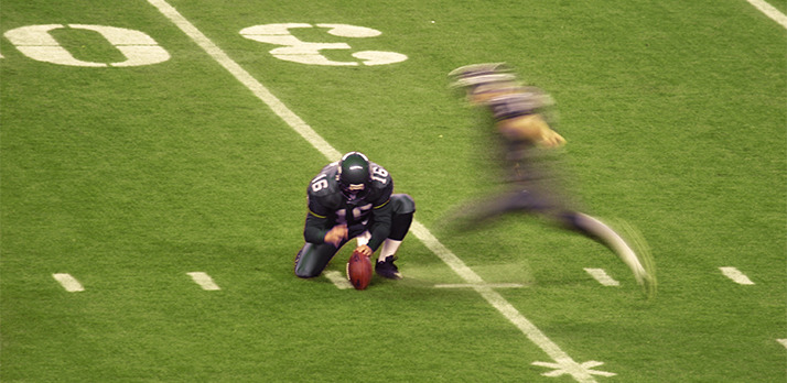 Shutter speed impacting the action photo of a football long snap holder and kicker