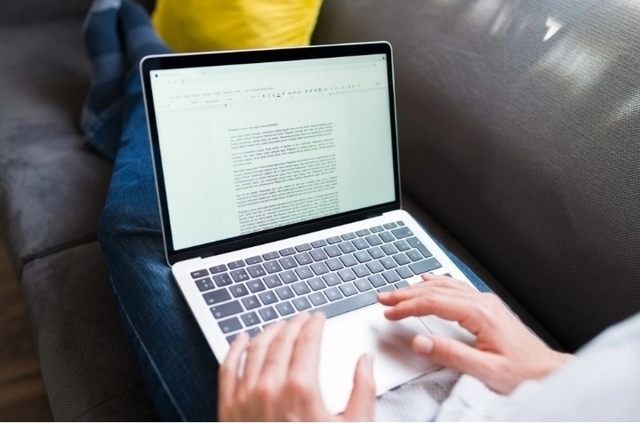Grafik zeigt eine Person, die am Laptop an einem Textdokument arbeitet.