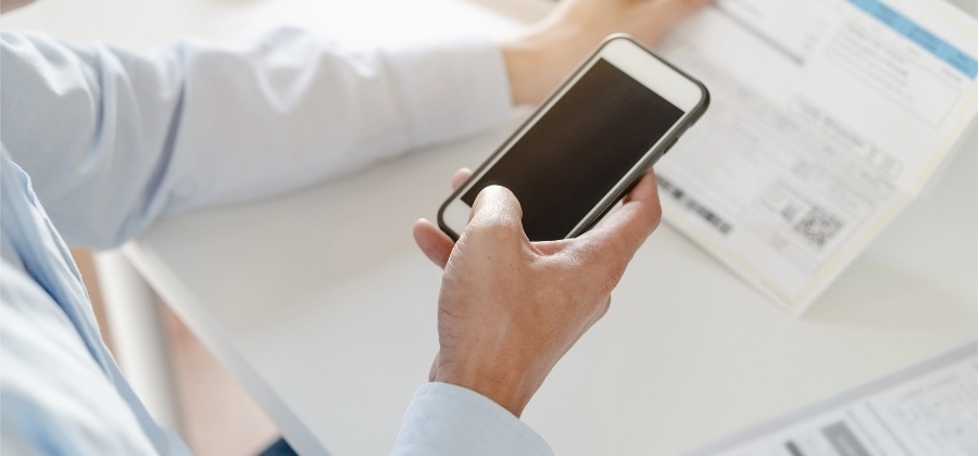 Ein Mann scannt ein Dokument mithilfe einer OCR Anwendung auf dem Smartphone.