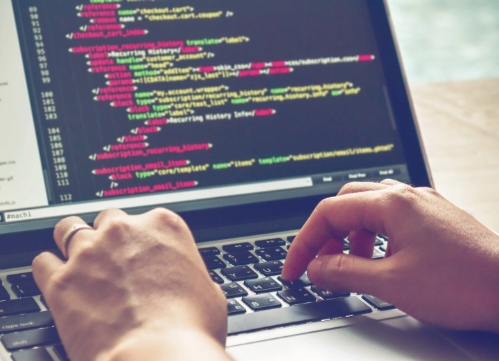 La imagen de un ordenador portátil con código HTML muestra lo similares que son HTML y XML.