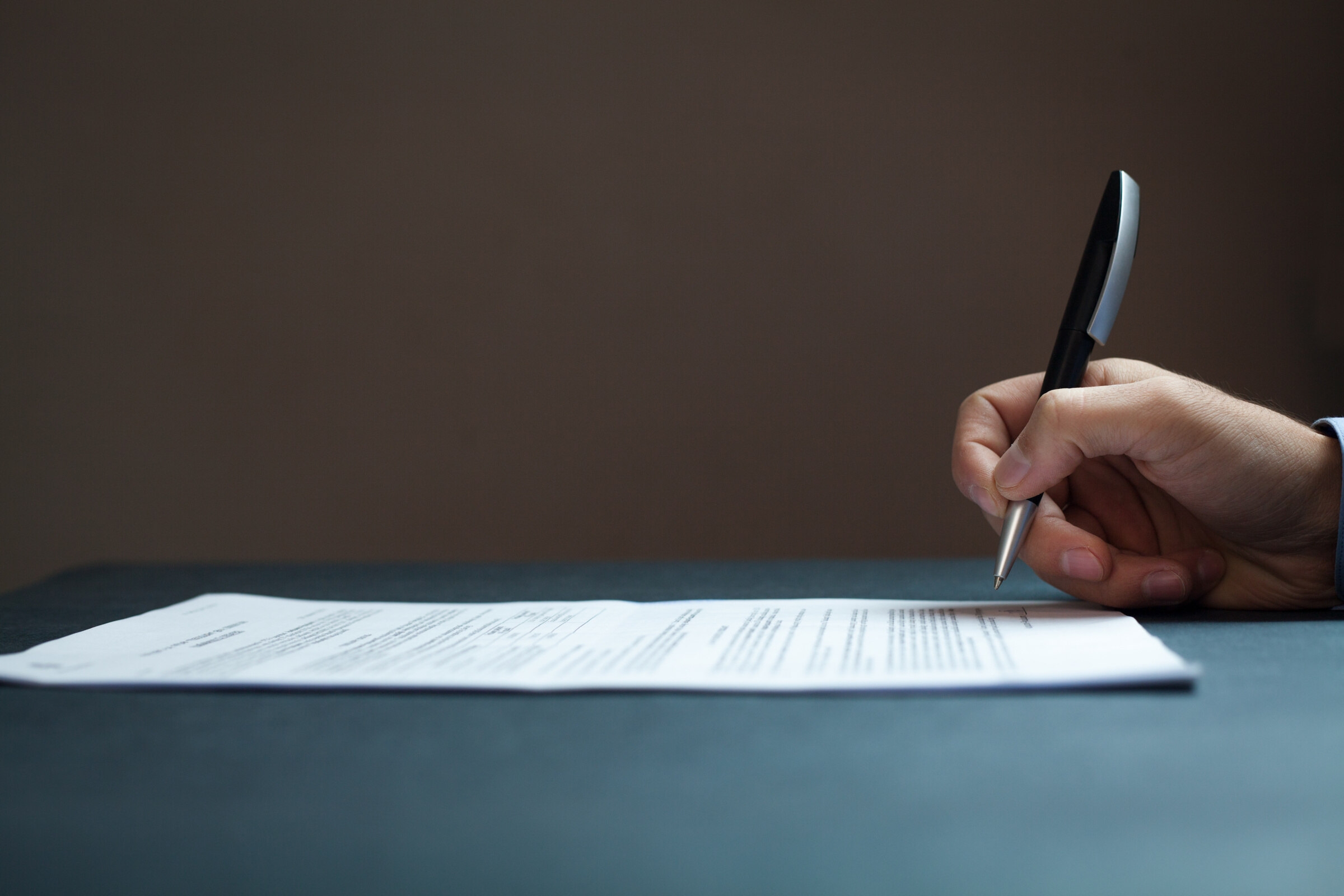 Une personne signe sa lettre de motivation