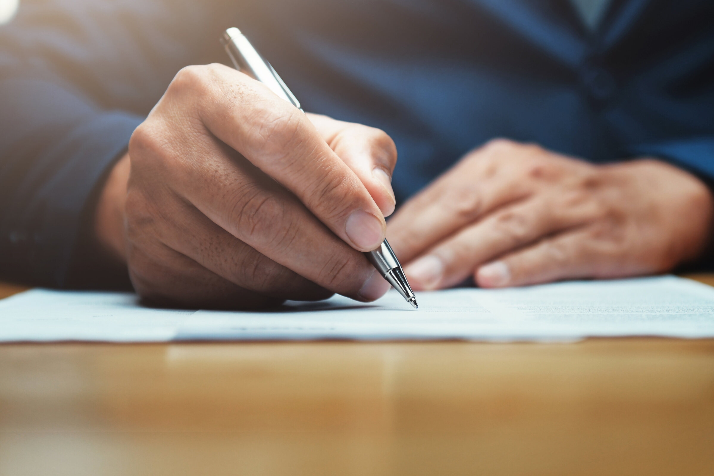 Un homme rédige une lettre de motivation pour une école