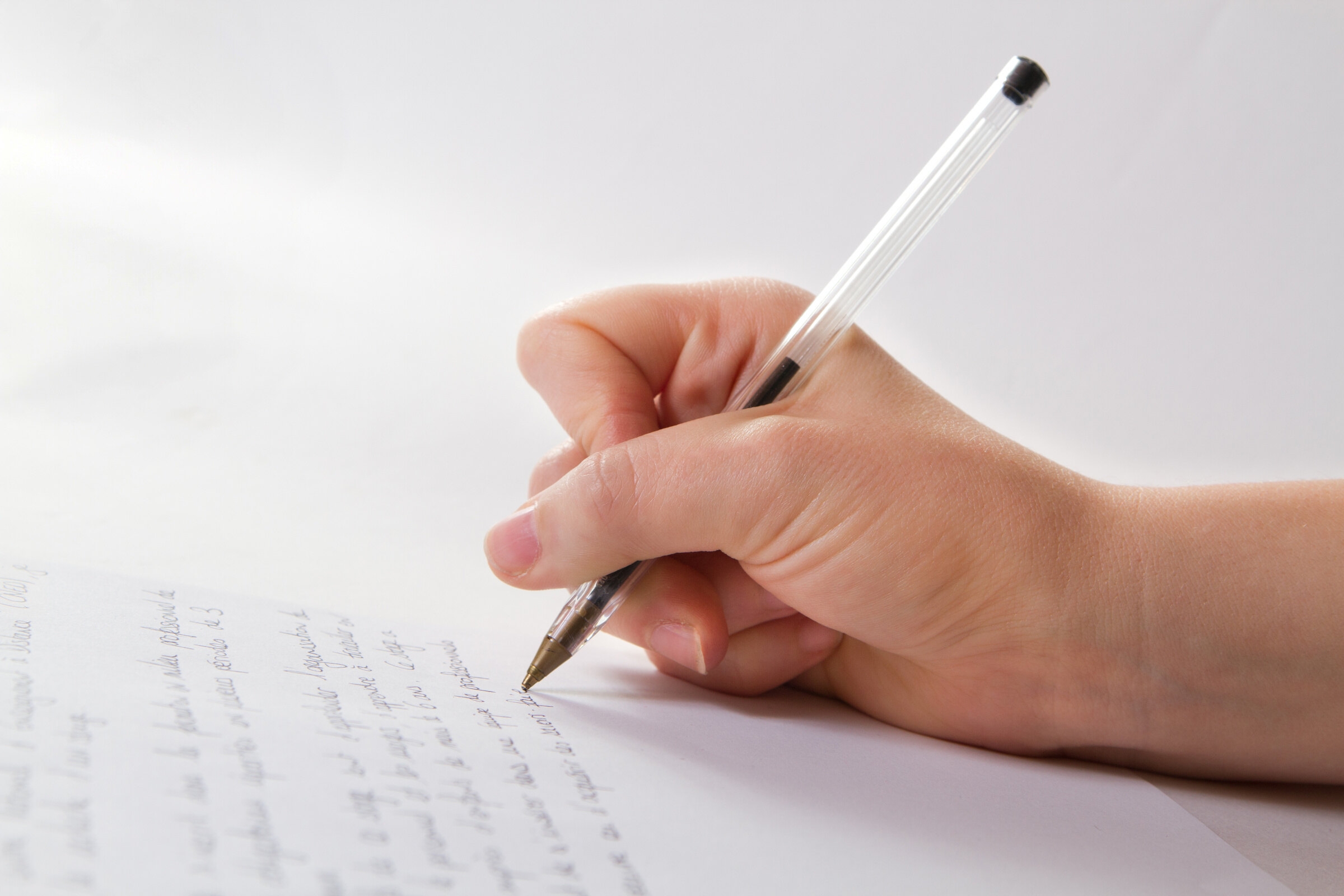 Une main rédige une lettre de motivation en anglais