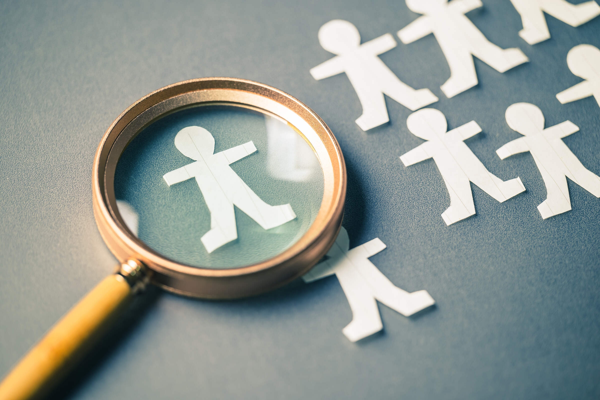 Une loupe sur un personnage en papier pour symboliser le choix du recruteur