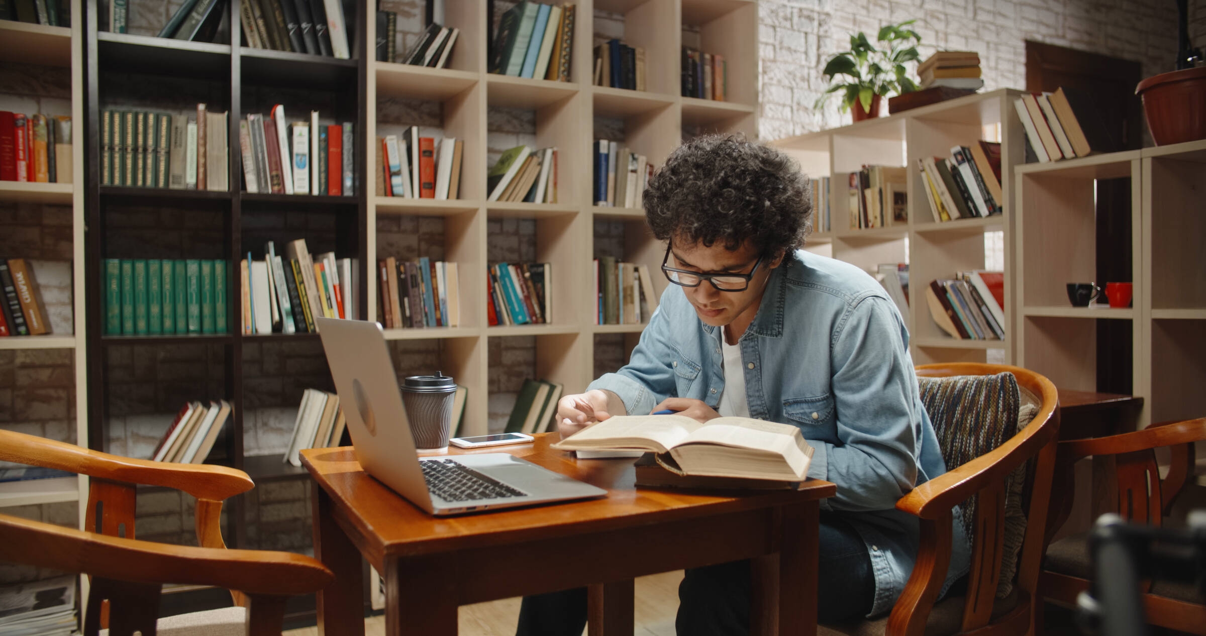 Un étudiant en droit lit un livre dans une bibliothèque