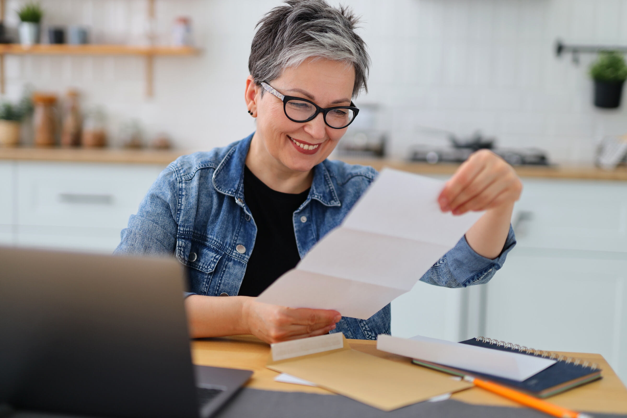 Une femme lit une lettre de motivation pour Master 1 et sourit
