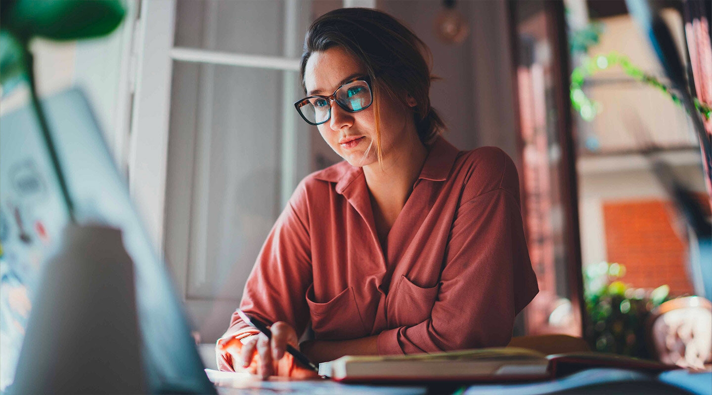 A person sitting at a desk looking at their computer
