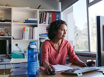 A person sitting at a desk looking at their computer