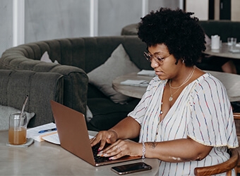A person sitting at a table using their laptop