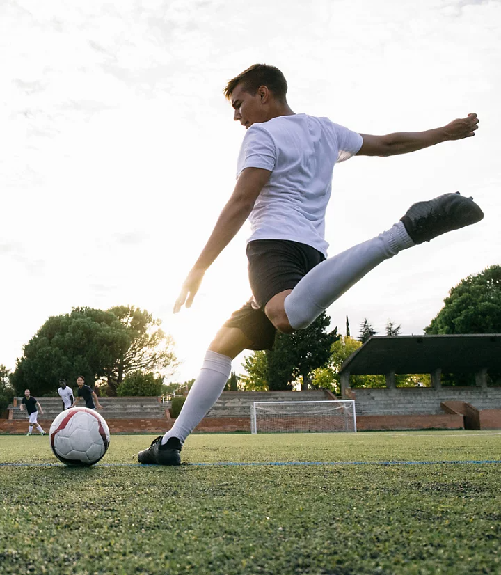 An action photo of a soccer player kicking a ball.
