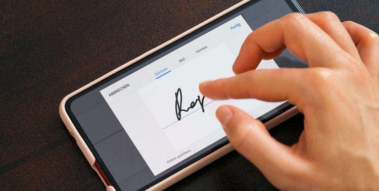 Bild zeigt Person, die ein Dokument elektronisch auf ihrem Smartphone unterzeichnet.
