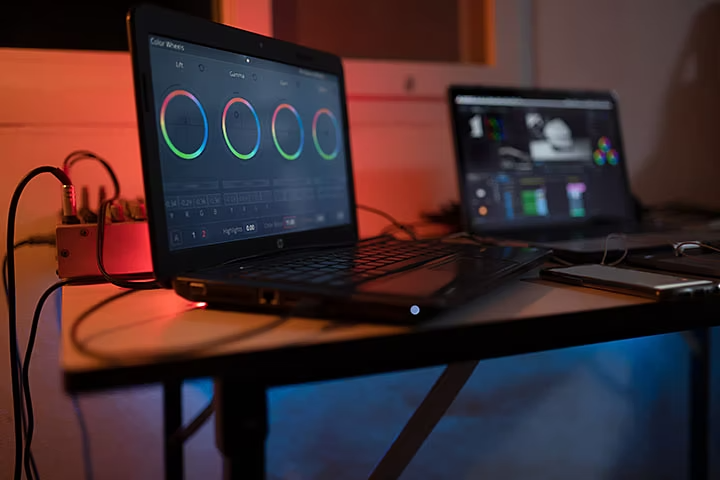 Two laptops on desk running colour editing software.