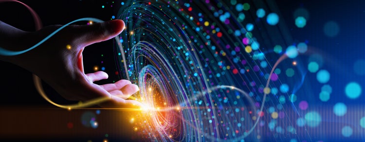 Das Bild zeigt eine Hand, die sich vor einem dunklen Hintergrund in Richtung eines spiralförmigen, leuchtenden Musters ausstreckt. Bunte Lichtpunkte und Linien umgeben die Spirale und erzeugen einen dynamischen, futuristischen Eindruck.