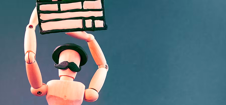 Wooden dummy with hat and moustache holding plasticine clapboard.