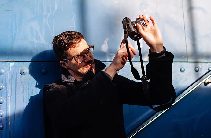 Eine Person fotografiert draußen mit einer spiegellosen Kamera.
