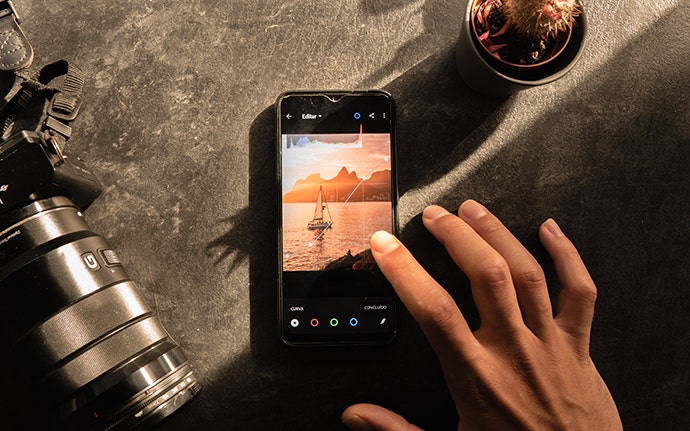 Mann, der ein Foto mit einem Smartphone bearbeitet.