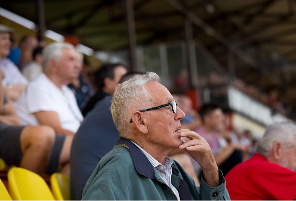 Mann filmt Fußballspiel