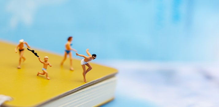 Spielfiguren in Badeszene auf gelbem Buch