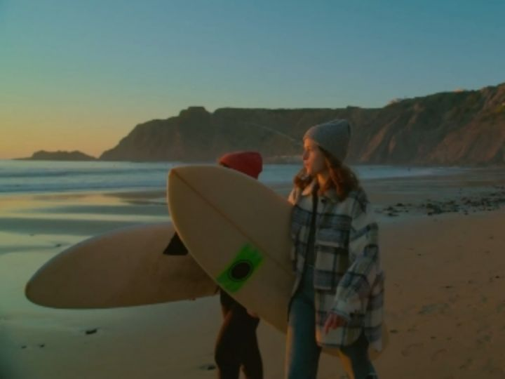 Video: Ein Video von Surfern, die am Strand entlanglaufen, mit angewendetem Filter.