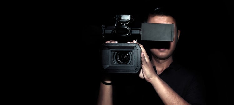 Kameramann hält Kamera in Normalsicht in die Kamera