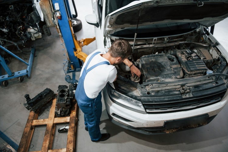 Vogelperspektive von einem Automechaniker bei der Arbeit an einem Auto