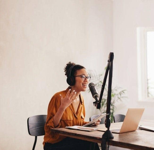 A person practicing recording their podcast by using a microphone
