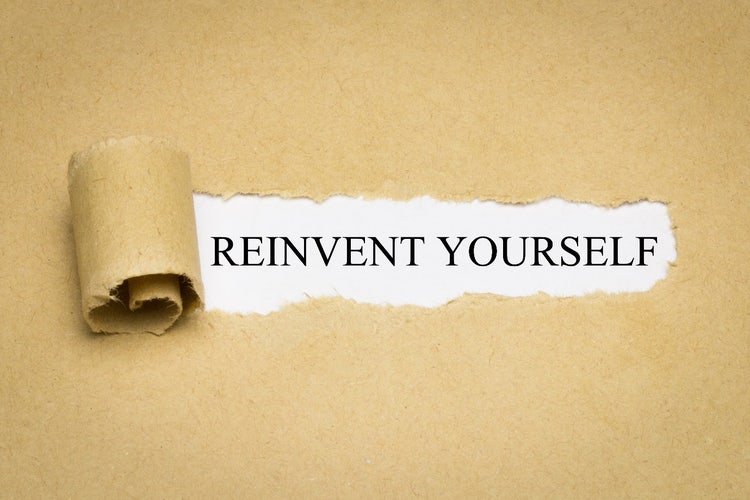 Zerrissenes Papier deckt den Slogan „Reinvent Yourself“ auf.  