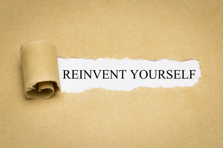 Zerrissenes Papier deckt den Slogan „Reinvent Yourself“ auf.