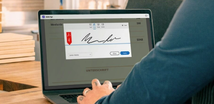 Bild zeigt eine Person, die mit Acrobat Sign auf dem Laptop ein Dokument signiert.