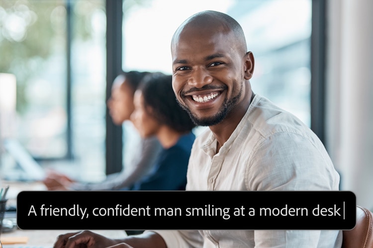 Billede af en smilende person, der sidder ved et moderne skrivebord, med en beskrivelse med ordene: "A friendly, confident man smiling at a modern desk".