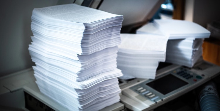 El gráfico muestra varias pilas de papel impresas en una impresora.